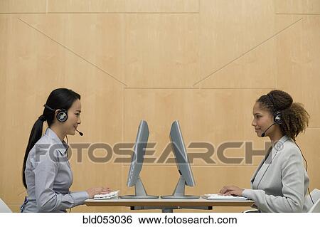 Stock Photograph - Multi-ethnic businesswomen wearing headsets. Fotosearch