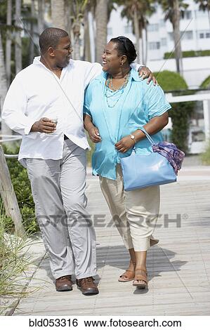 Stock Photograph - Multi-ethnic couple smiling at each other. Fotosearch