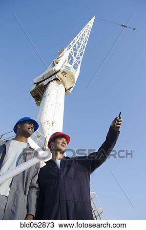 Multi-ethnic male construction workers under crane View Large Photo Image Stock Image - Multi-ethnic male construction workers under crane. Fotosearch