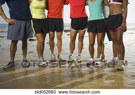 Stock Image - Multi-ethnic runners at beach. Fotosearch