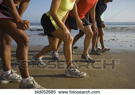 Stock Photography - Multi-ethnic runners racing at beach. Fotosearch
