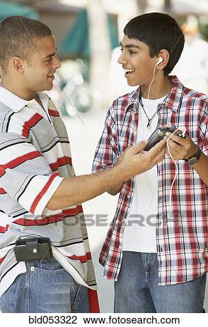 Multi-ethnic teenaged boys holding mp3 player View Large Photo Image Stock Image - Multi-ethnic teenaged boys holding mp3 player. Fotosearch