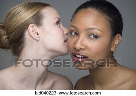 Stock Image - Multi-ethnic women telling secret. Fotosearch