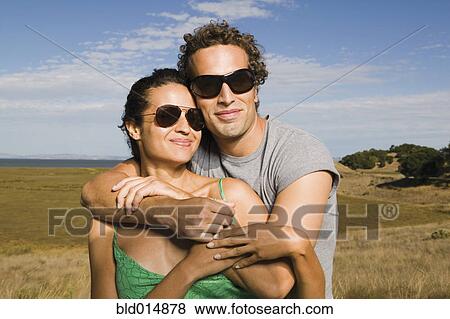 Portrait of couple wearing sunglasses and hugging View Large Photo Image Stock Photo - Portrait of couple wearing sunglasses and hugging. Fotosearch