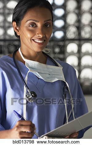 Stock Photo - Portrait of female doctor writing notes. Fotosearch