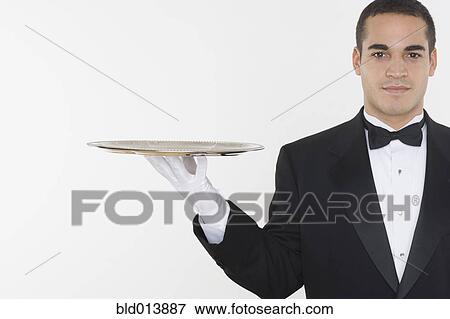 Stock Photo - Portrait of male waiter balancing tray. Fotosearch