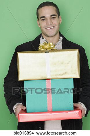 Portrait of man holding stack of gifts View Large Photo Image Picture - Portrait of man holding stack of gifts. Fotosearch