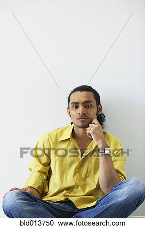 Portrait of man sitting on floor with hand on face View Large Photo Image Stock Image - Portrait of man sitting on floor with hand on face. Fotosearch