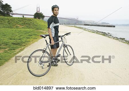 Portrait of man with bike with Golden Gate Bridge behind him View Large Photo Image Stock Photo - Portrait of man with bike with Golden Gate Bridge behind him. Fotosearch