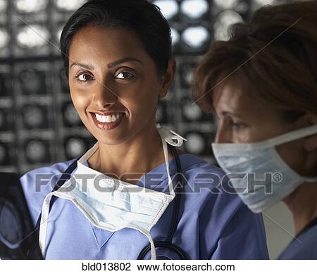 Stock Image - Portrait of two female doctors in scrubs. Fotosearch