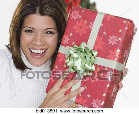 Stock Image - Portrait of woman holding gift. Fotosearch