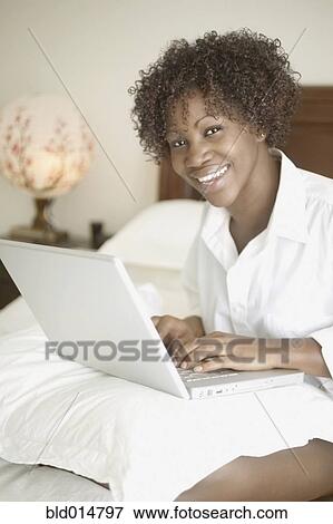Portrait of woman in bed with laptop View Large Photo Image Stock Photo - Portrait of woman in bed with laptop. Fotosearch