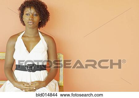 Picture - Portrait of woman in white dress sitting. Fotosearch