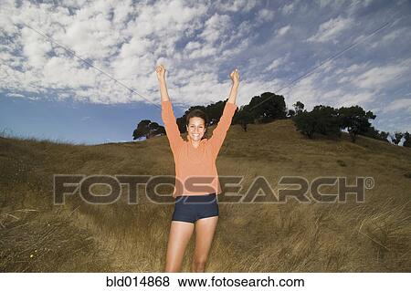 Portrait of woman standing with hands above head View Large Photo Image Stock Photo - Portrait of woman standing with hands above head. Fotosearch