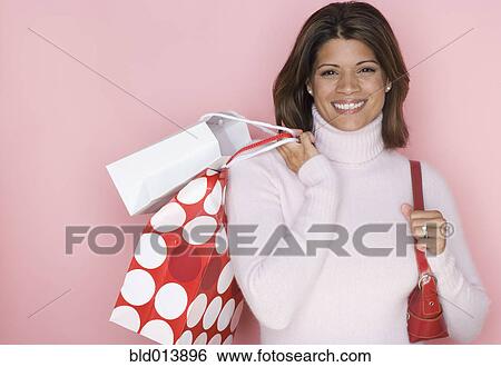 Portrait of woman with gift bags over shoulder View Large Photo Image Stock Photograph - Portrait of woman with gift bags over shoulder. Fotosearch
