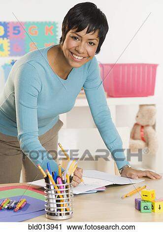 Portrait of woman writing in notebook at desk View Large Photo Image Stock Image - Portrait of woman writing in notebook at desk. Fotosearch