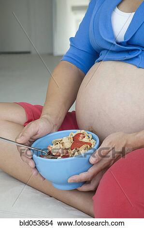 Pregnant African woman eating cereal View Large Photo Image Picture - Pregnant African woman eating cereal. Fotosearch
