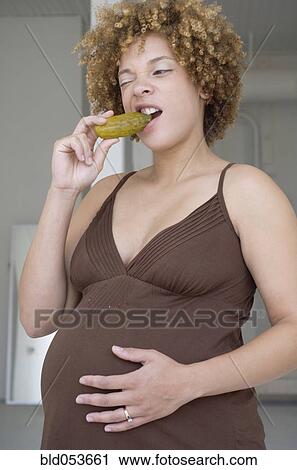 Pregnant African woman eating pickle View Large Photo Image Stock Image - Pregnant African woman eating pickle. Fotosearch