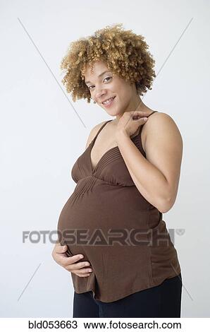 Pregnant African woman with hand on belly View Large Photo Image Stock Image - Pregnant African woman with hand on belly. Fotosearch