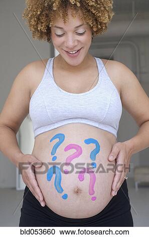 Pregnant African woman with question marks painted on belly View Large Photo Image Stock Image - Pregnant African woman with question marks painted on belly. Fotosearch