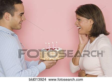 Profile of man holding cake and looking at woman View Large Photo Image Picture - Profile of man holding cake and looking at woman. Fotosearch