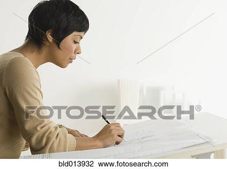 Stock Image - Profile of woman drawing plans. Fotosearch