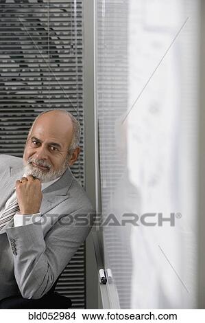 Picture - Senior African businessman next to whiteboard. Fotosearch