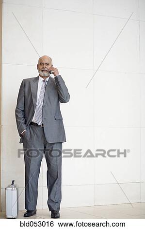 Stock Photograph - Senior African businessman talking on cell phone. Fotosearch