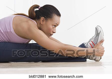 Side view of woman stretching View Large Photo Image Stock Image - Side view of woman stretching. Fotosearch