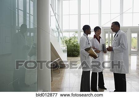Three doctors conferring View Large Photo Image Stock Photo - Three doctors conferring. Fotosearch