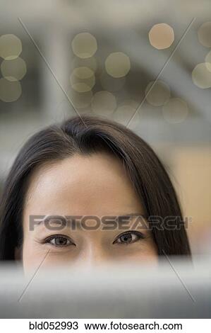 Stock Image - Top half of Asian woman's face. Fotosearch