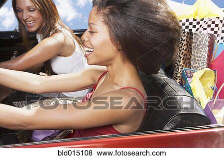Stock Photo - Two woman driving convertible. Fotosearch