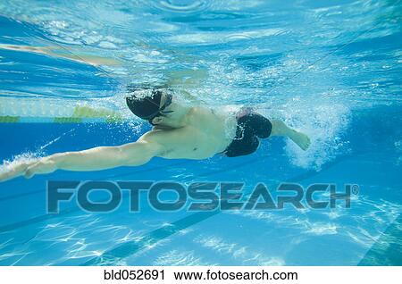 Stock Image - Underwater shot of Asian man swimming. Fotosearch