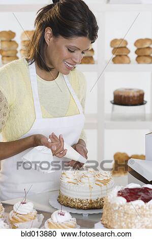 Woman decorating cake at bakery View Large Photo Image Stock Image - Woman decorating cake at bakery. Fotosearch