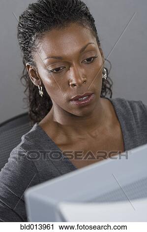Stock Image - Woman in office working on computer. Fotosearch