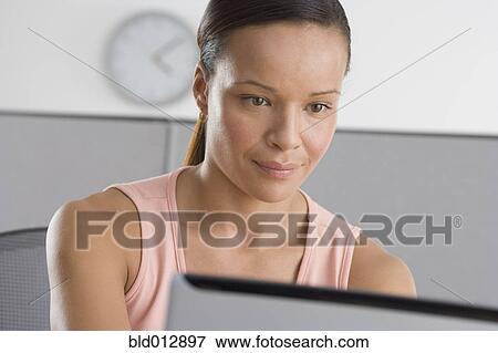 Woman in office working on computer View Large Photo Image Stock Photo - Woman in office working on computer. Fotosearch