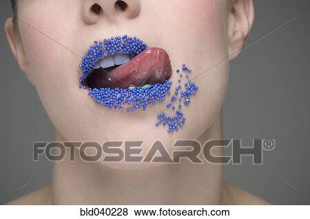 Stock Photo - Woman licking sprinkles off lips. Fotosearch