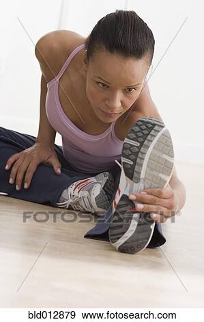 Woman on floor stretching View Large Photo Image Stock Photo - Woman on floor stretching. Fotosearch