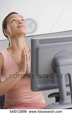 Woman praying in office View Large Photo Image Stock Photo - Woman praying in office. Fotosearch