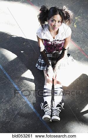 Stock Image - Young Asian woman wearing funky clothing. Fotosearch