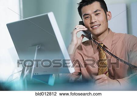 Young businessman talking on telephone View Large Photo Image Stock Image - Young businessman talking on telephone. Fotosearch