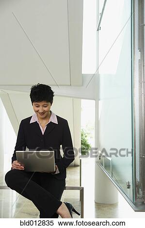 Stock Photography - Young businesswoman with laptop computer. Fotosearch