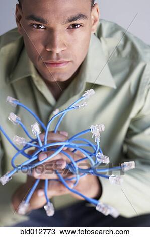 Young man holding Ethernet cables View Large Photo Image Stock Image - Young man holding Ethernet cables. Fotosearch