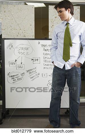 Stock Photo - Young man standing in front of whiteboard. Fotosearch