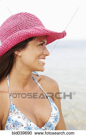 Young woman wearing hat at beach View Large Photo Image Stock Image - Young woman wearing hat at beach. Fotosearch
