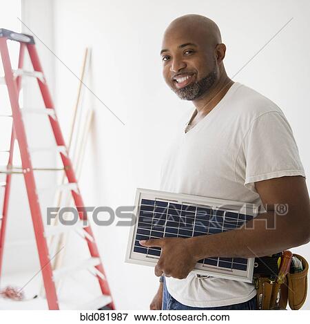 African American construction worker carrying solar panel View Large Photo Image Stock Photo - African American construction worker carrying solar panel. Fotosearch
