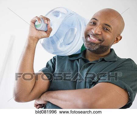 African American deliveryman holding water bottle View Large Photo Image Stock Photograph - African American deliveryman holding water bottle. Fotosearch