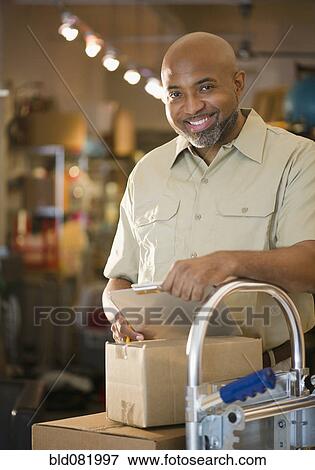 African American deliveryman with clipboard and boxes View Large Photo Image Stock Photo - African American deliveryman with clipboard and boxes. Fotosearch