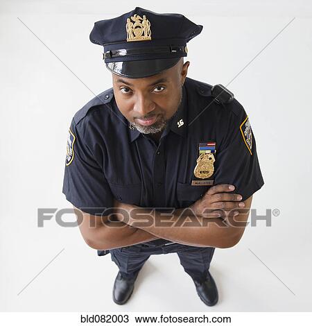 Stock Image - African American policeman with arms crossed. Fotosearch