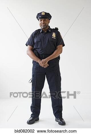 Stock Image - African American policeman with hands clasped. Fotosearch